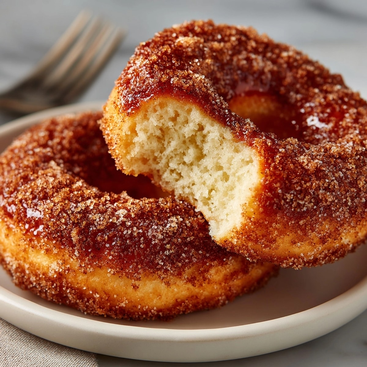 Golden baked Maple Apple Cider Donuts coated in cinnamon sugar, ready to serve.