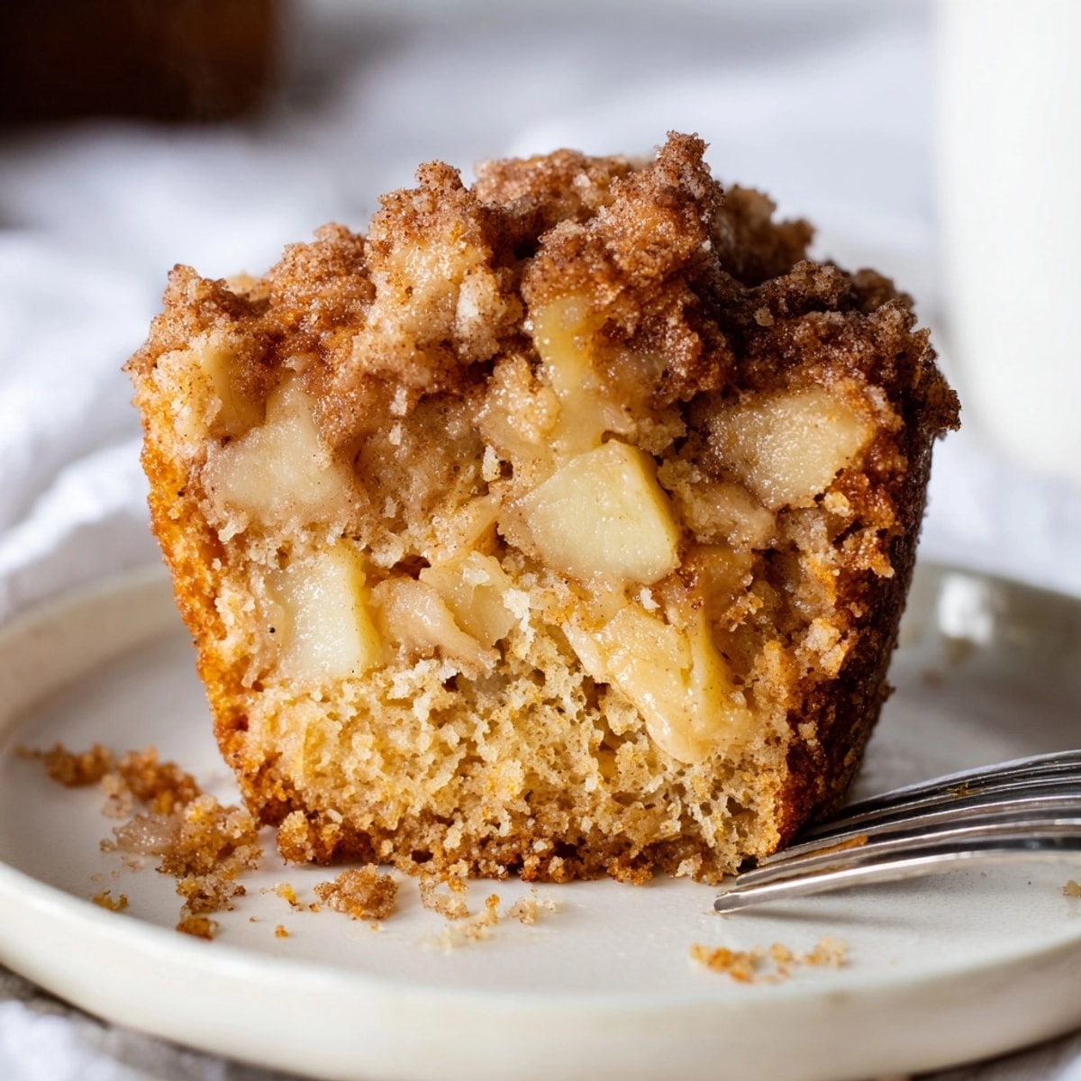 Warm, comforting Apple Cinnamon Muffins, streusel crumb topping visible, ready to enjoy with coffee.