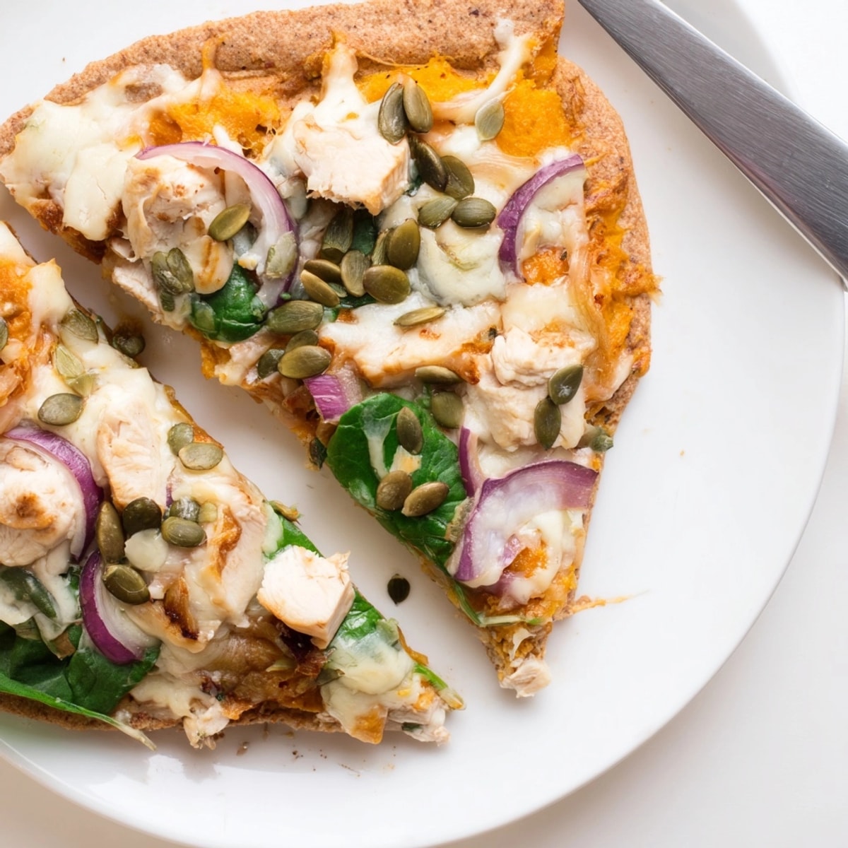 Close-up of golden Protein Pumpkin Ricotta Pizza with melted cheese, ready to serve.