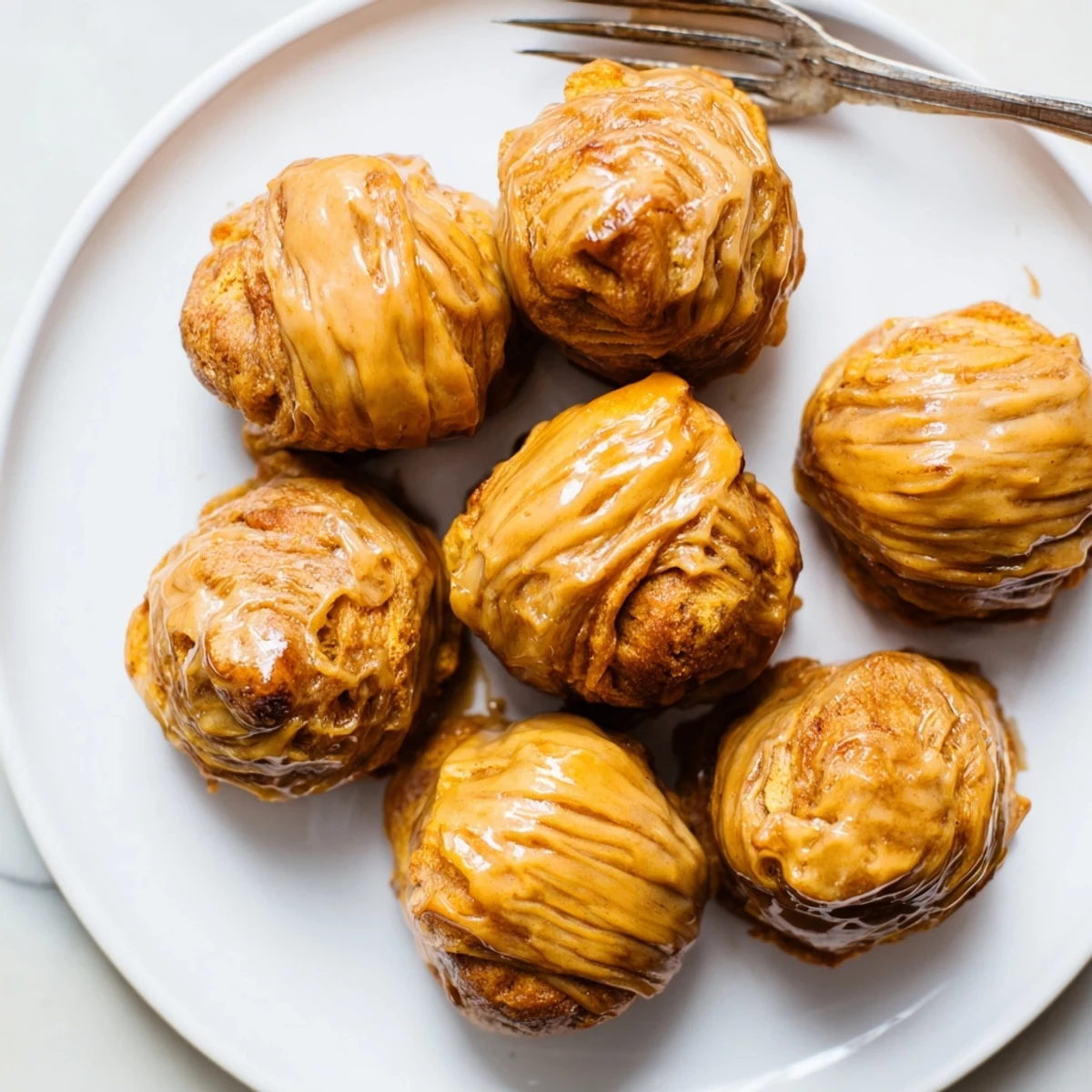 Decadent Maple Bourbon Flaky Pumpkin Muffin Balls drizzled with rich glaze, perfect for fall.
