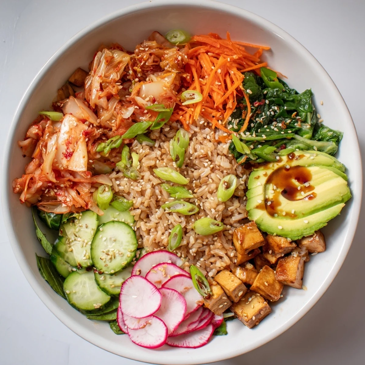 Delicious fermented vegetable bowl drizzled with sesame dressing and topped with radishes.