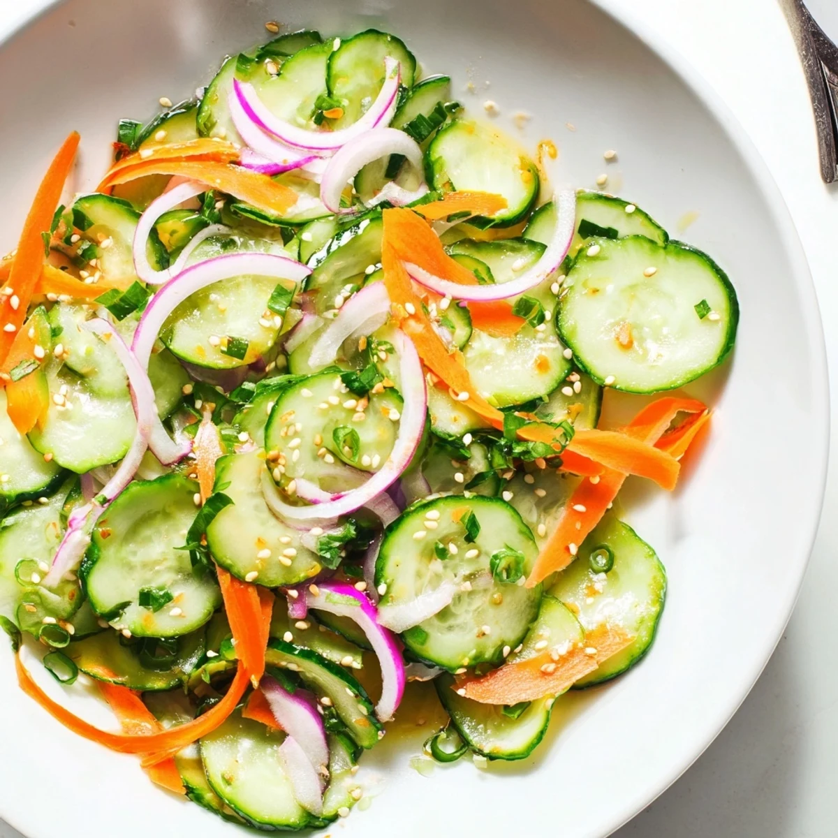 Refreshing cucumber salad remix with sesame oil and cilantro, served chilled.  