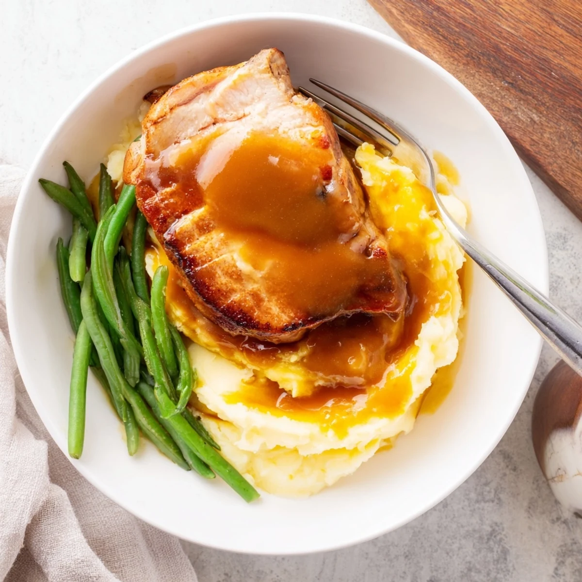Juicy pork chops served over creamy cheddar mash, drizzled with savory pan gravy.  