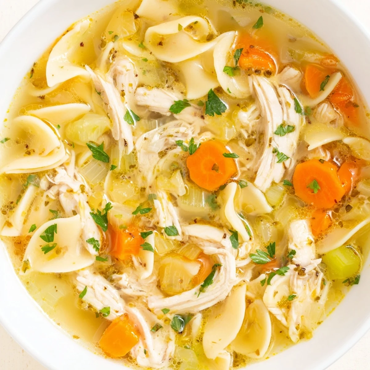 Steaming bowl of homemade chicken noodle soup, with tender chicken and herbs, perfect comfort food.