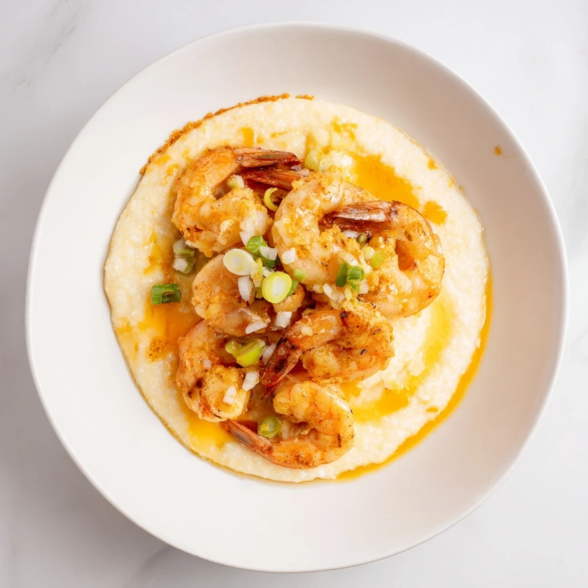 Steaming bowl of creamy Shrimp & Grits with garlic butter sauce, a true Southern comfort food.