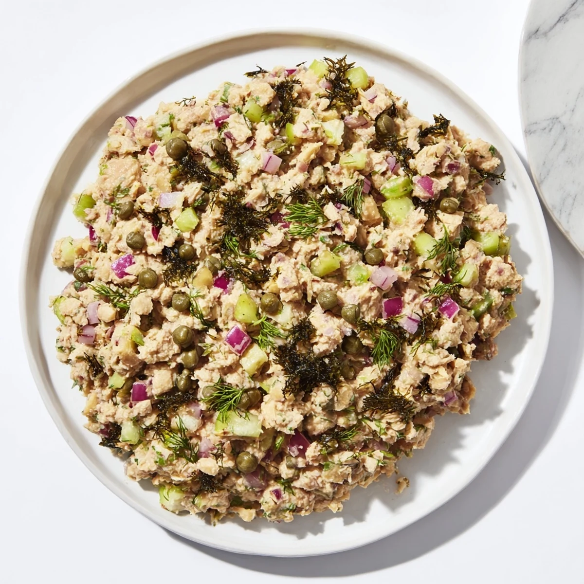 Creamy chickpea tuna salad, a vegan delight with fresh dill pickle and vibrant ingredients.