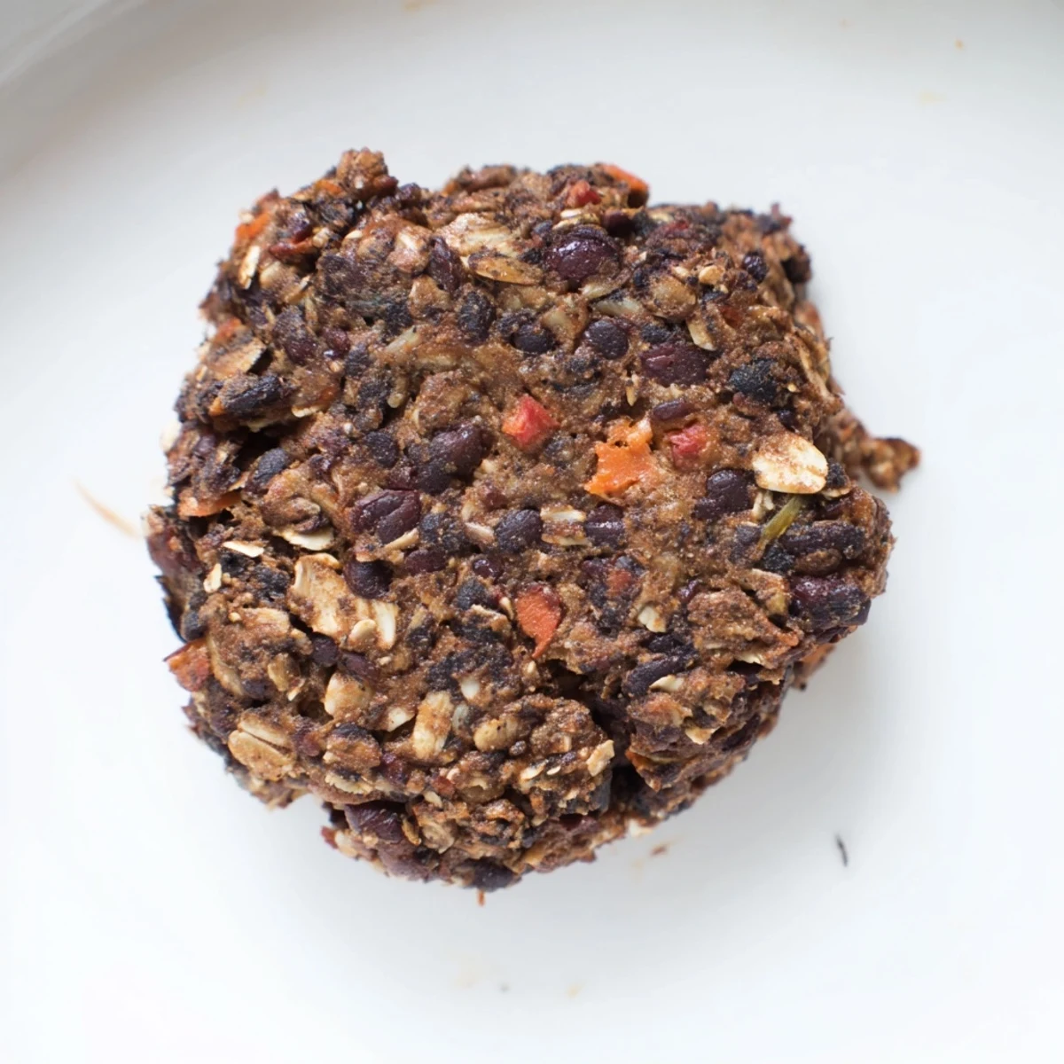 Golden-brown, crispy black bean burgers served on a toasted bun with fresh tomato and avocado.