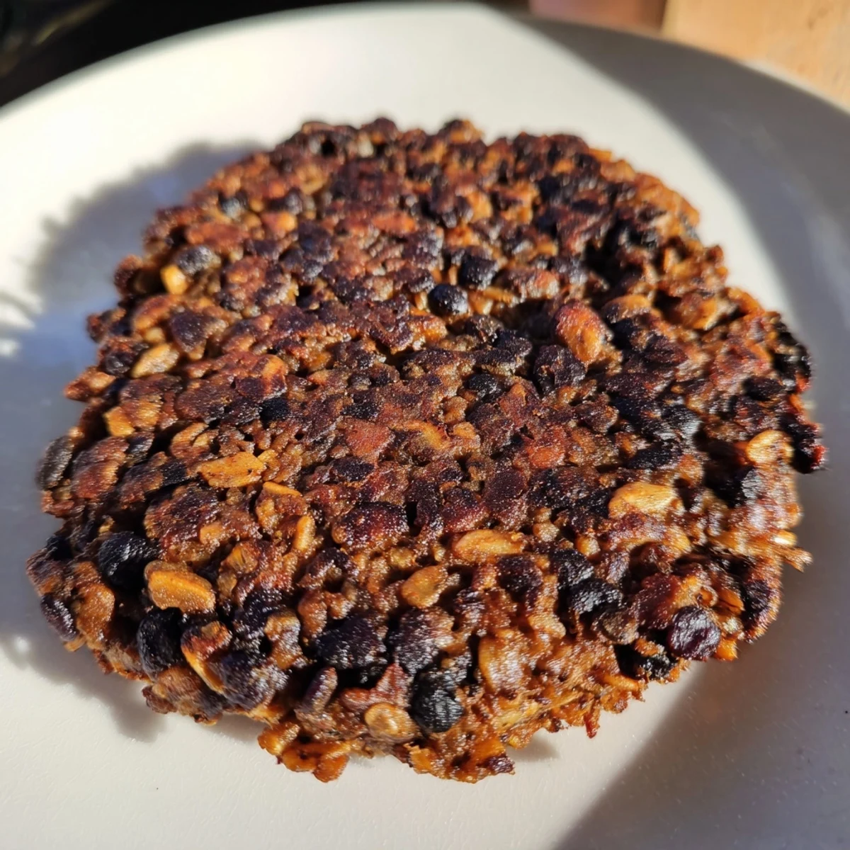 Savory black bean burgers, packed with vegetables, are sizzling in a skillet, ready to serve.