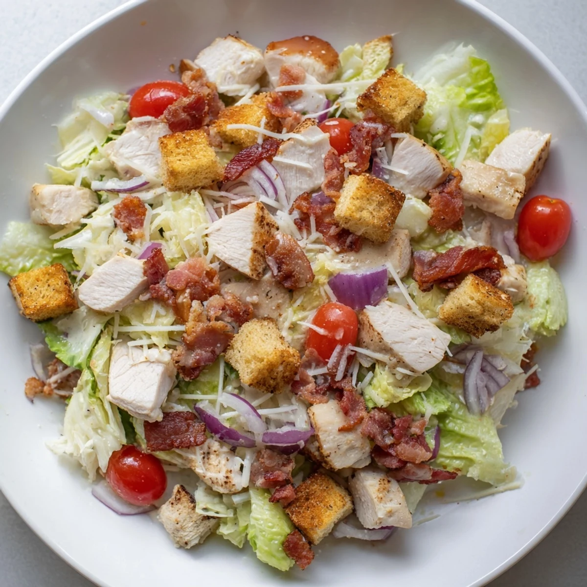 Costco Chicken Bake Salad Bowl with crisp romaine, juicy tomatoes, and a creamy Caesar dressing.