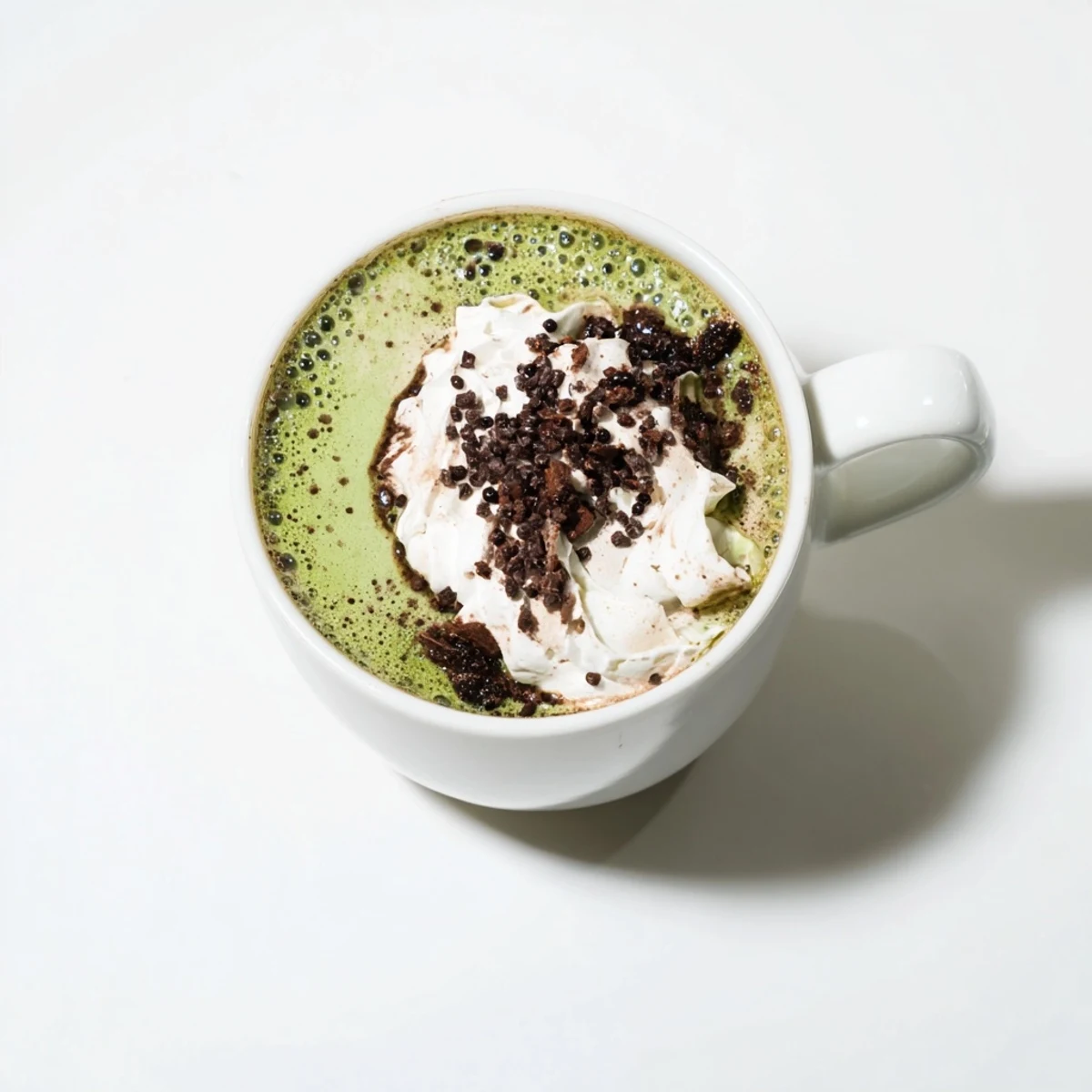 Steaming Collagen Peppermint Mocha Matcha Latte, a vibrant green and cocoa-brown drink topped with whipped cream.