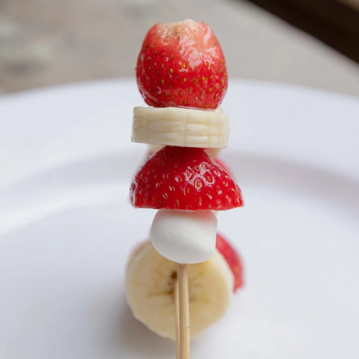 Festive strawberry banana Santa sticks: a delightful holiday snack with fresh fruit and marshmallows.