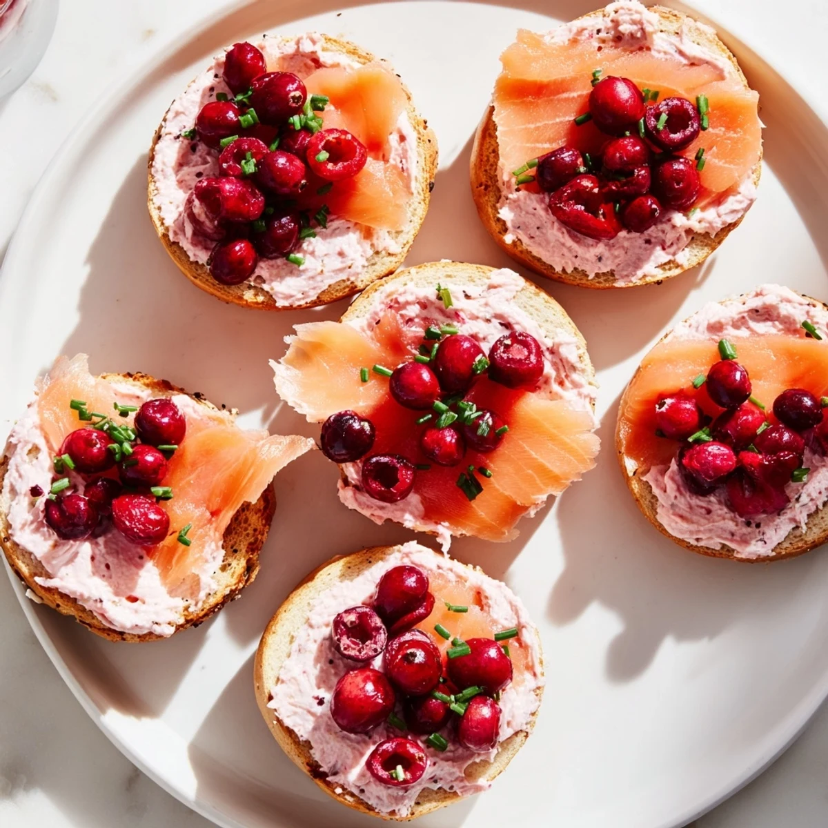 Festive Cranberry Sleigh Bagel Board with vibrant colors, featuring bagels, salmon, and fruit.