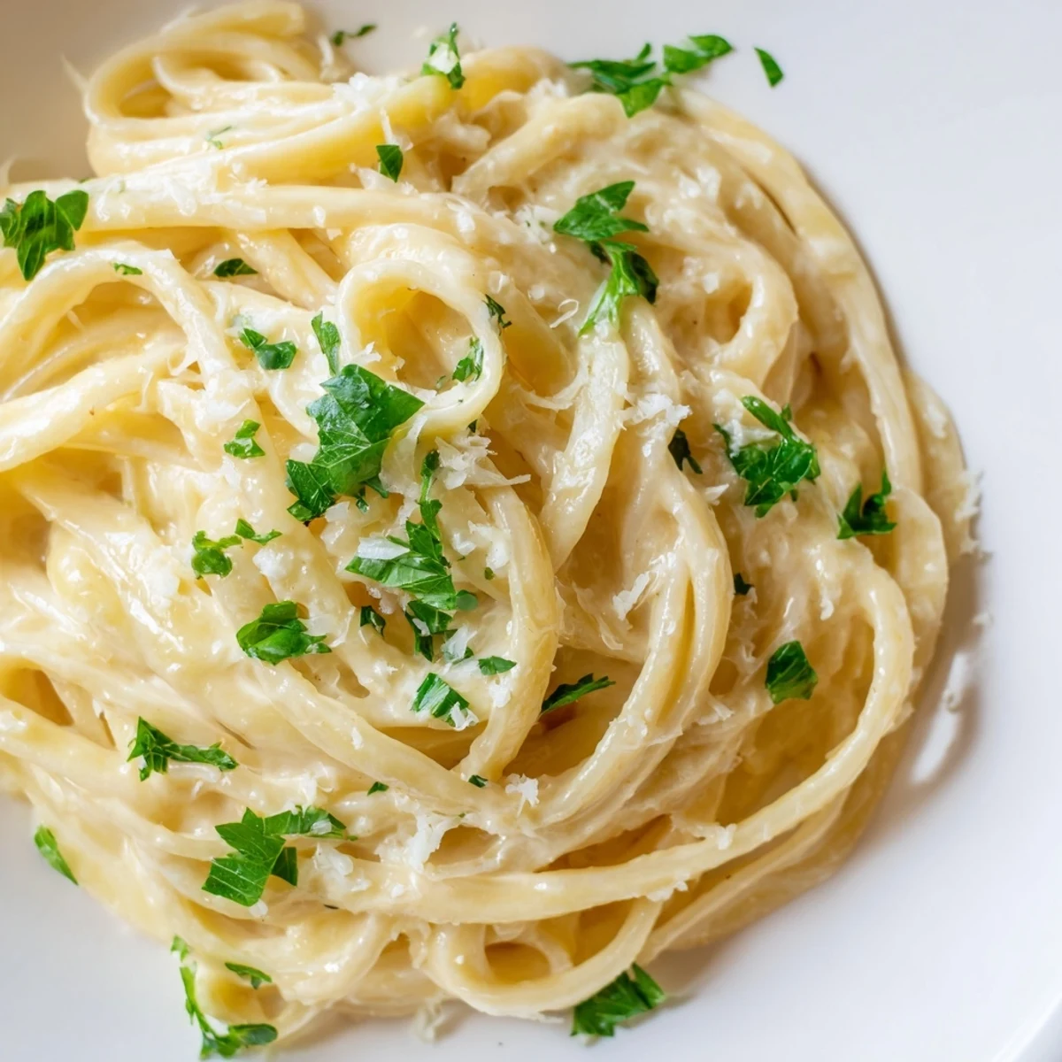 A bowl of steaming sriracha honey pasta with a glossy, creamy sauce and red pepper flakes.