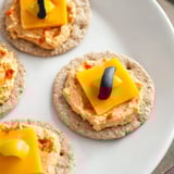 Warm, gooey Santa's Belt Crackers featuring melted cheddar and a vibrant roasted red pepper dip for serving.