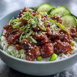Hearty Korean Ground Beef Bowl topped with crunchy edamame, carrots, cucumber, and spicy kimchi on white rice.