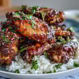 Golden-brown honey garlic wings glazed with sticky BBQ sauce, arranged over steamed rice for an easy dinner.