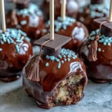Close-up of moist cake pop balls dipped in vibrant candy melts, topped with edible glitter and chocolate tassels.  