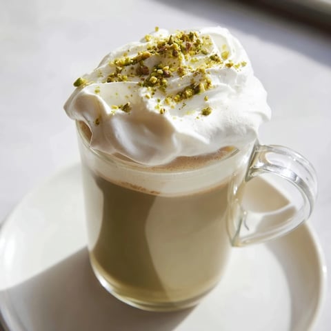 Steaming pistachio milk layered over espresso, forming a delicious Pistachio Latte Cloud beverage.