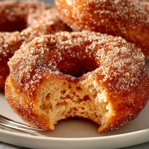 Homemade Maple Apple Cider Donuts cooling on a rack; sweet, spiced autumn treat.