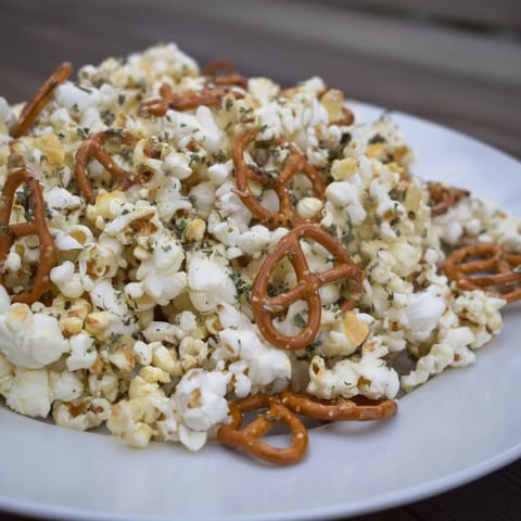 Homemade Garlic Herb Popcorn Snack Mix, a crunchy, aromatic blend of pretzels, nuts, popcorn.