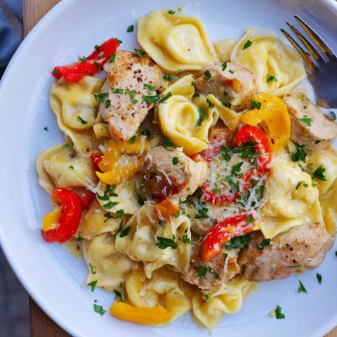 Zesty Cajun Garlic Parmesan Chicken Tortellini in a creamy sauce, garnished with fresh parsley.  