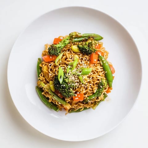 Close-up of a flavorful Ramen Noodle Stir-Fry Remix, showcasing noodles, vegetables, and a glossy sauce.