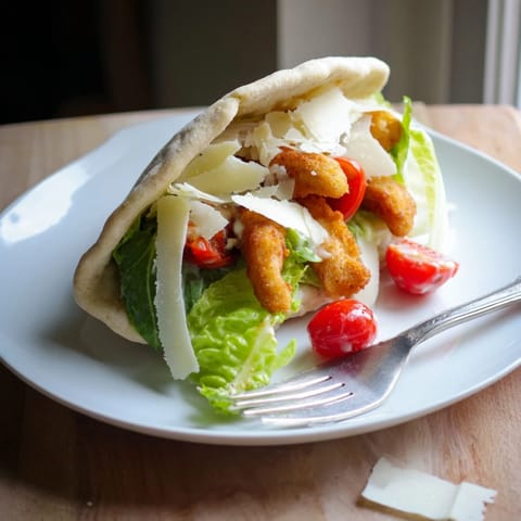 Golden, air-fried chicken strips tucked inside a warm pita pocket, creating a handheld Mediterranean-inspired meal perfect for easy weeknight dinners.