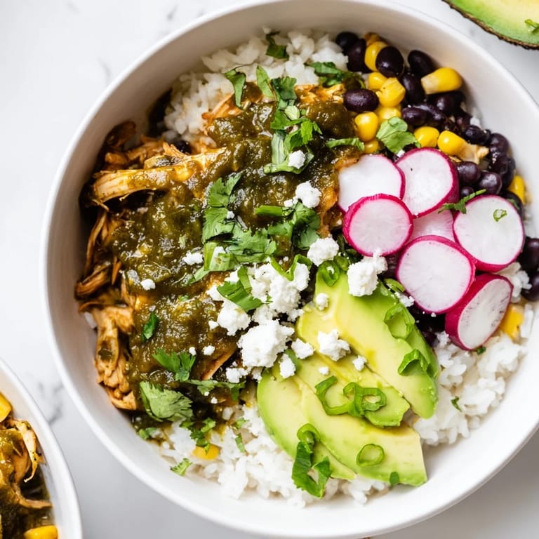 A delicious, colorful Green Enchiladas Rice Bowl, showcasing fluffy rice topped with flavorful chicken and fresh cilantro.