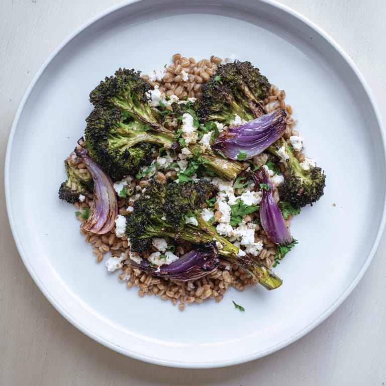 Golden roasted broccoli and red onion over fluffy farro, a Mediterranean-inspired dish ready to serve.