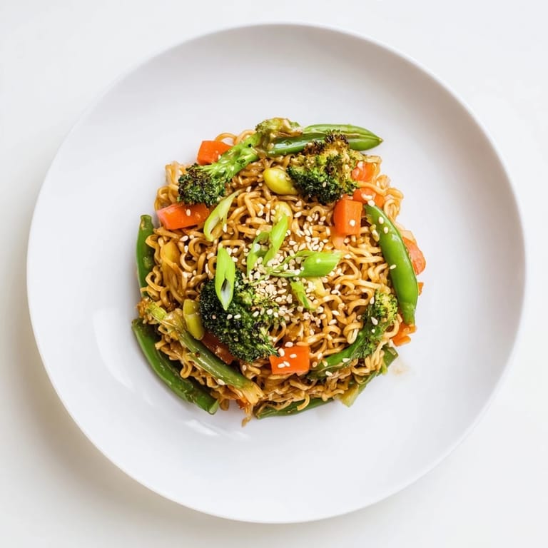 Close-up of a flavorful Ramen Noodle Stir-Fry Remix, showcasing noodles, vegetables, and a glossy sauce.