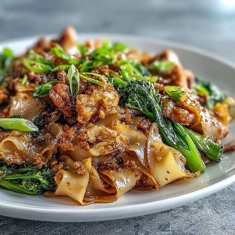 Steaming Authentic Thai Pad See Ew in a wok, featuring scrambled egg, savory oyster sauce, and crisp gai lan greens.