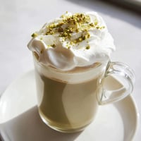 Steaming pistachio milk layered over espresso, forming a delicious Pistachio Latte Cloud beverage.
