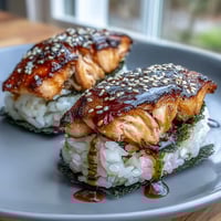 Grilled Salmon Onigiri: Tender rice balls filled with savory grilled salmon, lightly crisped on the outside for a satisfying Japanese snack.